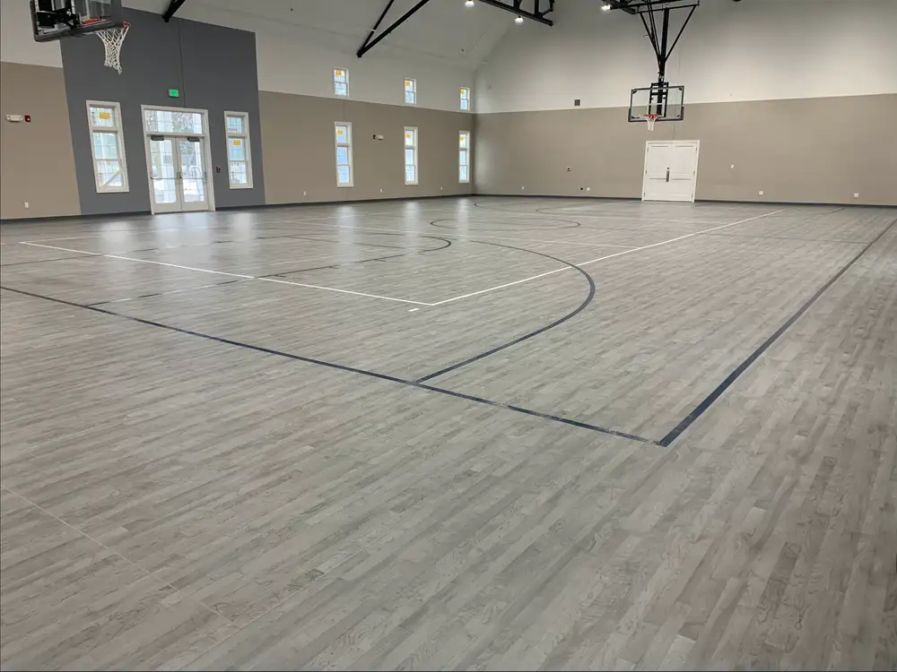Gymnasium with tan and gray wood-tone flooring